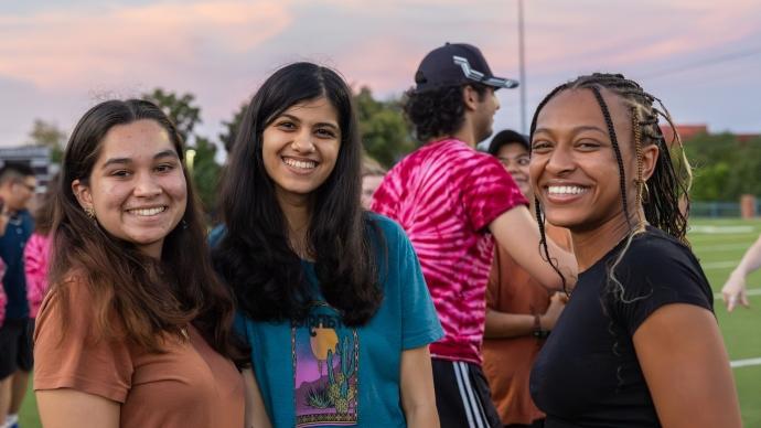 Three students pose for a photo outside